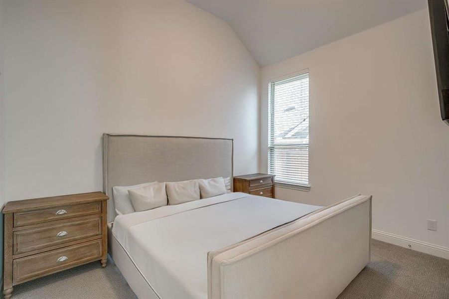 Carpeted bedroom with vaulted ceiling