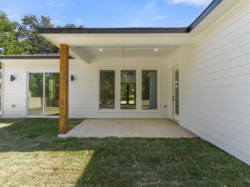 Back of property with a lawn and a patio