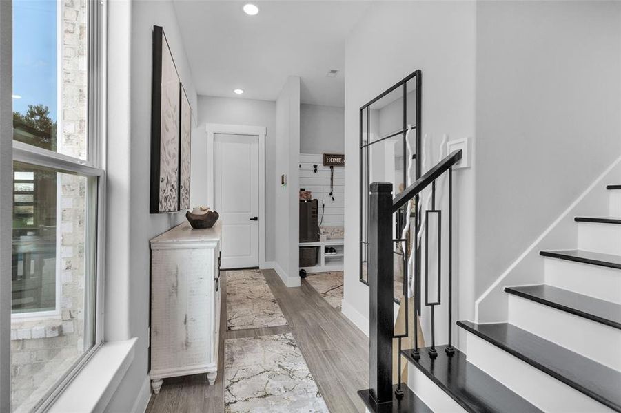 Modern iron balusters leading to wood stairway. Primary is on main floor beyond these stairs.