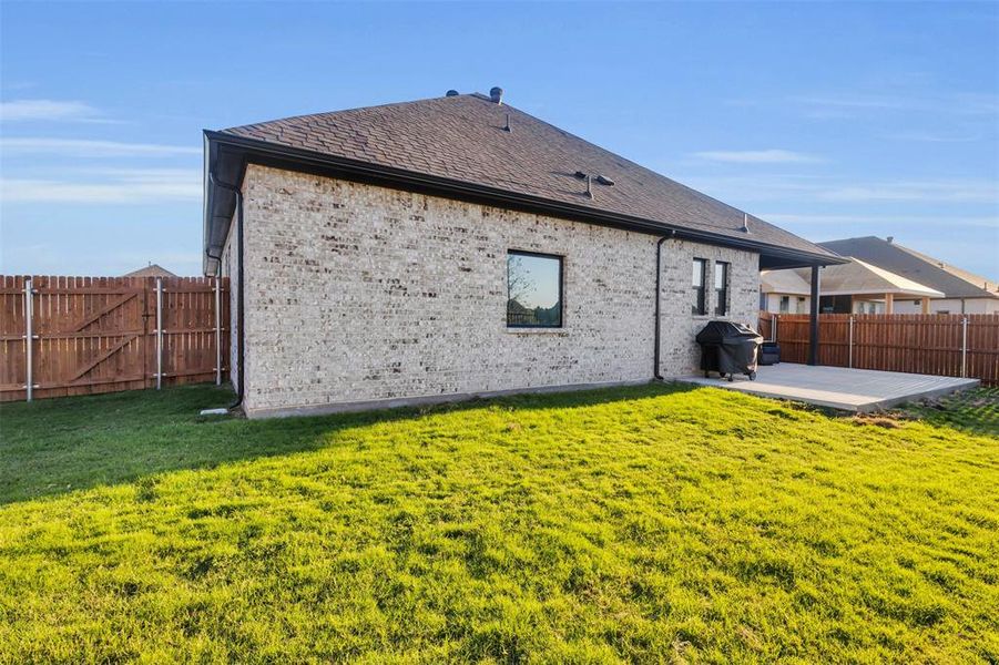 Back of property featuring a lawn and a patio