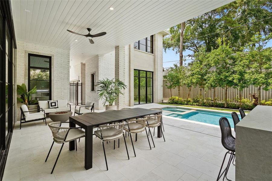 The covered veranda creates an ideal retreat, complete with ceiling fans to keep you cool and outdoor speakers for enjoying music as you unwind. Large sliding glass doors seamlessly retract into the living room -  welcoming the refreshing breeze on spring and late fall days.