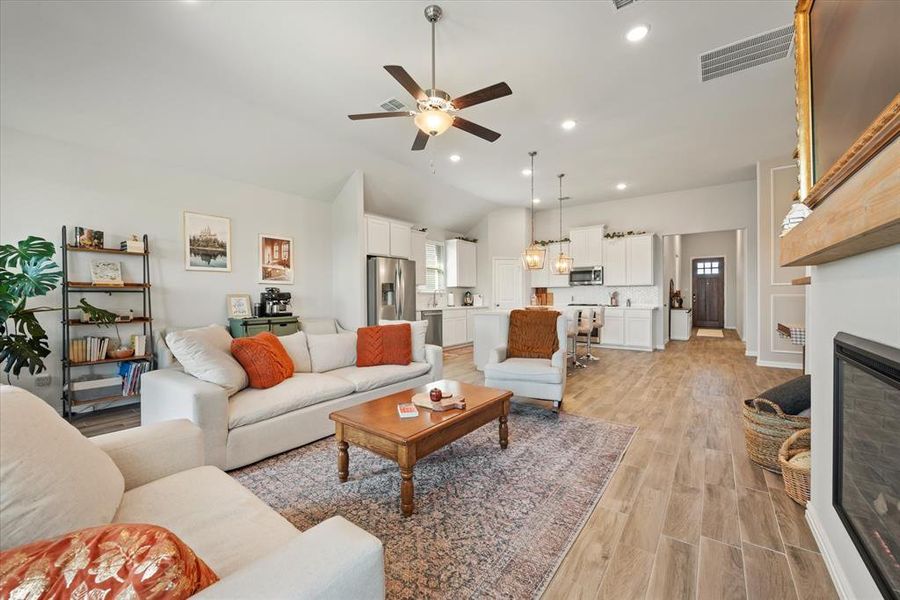 Living room with wood tile flooring, ceiling fan and electric fireplace