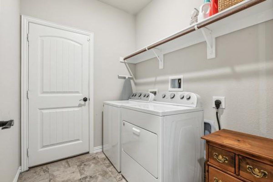 Laundry area with washing machine and clothes dryer and light tile patterned floors