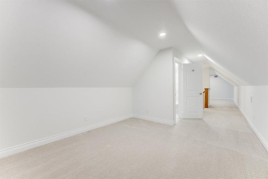 Another view of the finished-out upstairs space including a living area, a bedroom, a closet, and a full bath.