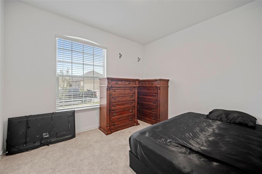 Bedroom with multiple windows and light colored carpet