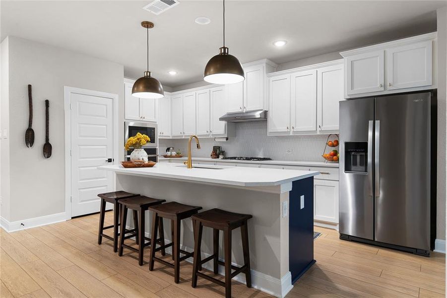 Kitchen featuring white cabinetry, sink, hanging light fixtures