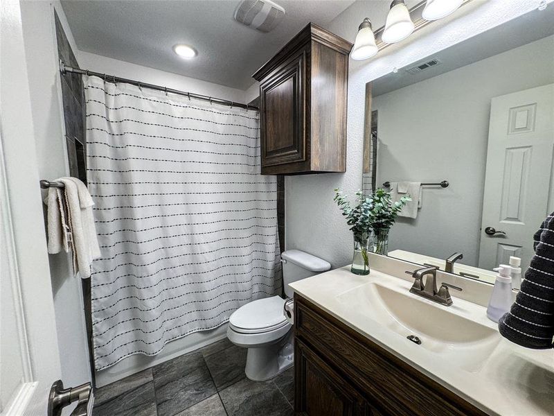 Full bathroom featuring vanity, shower / tub combo, toilet, and tile patterned floors