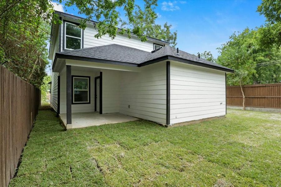 Rear view of house with a yard and a patio area