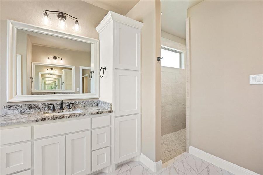 Bathroom with a tile shower and vanity