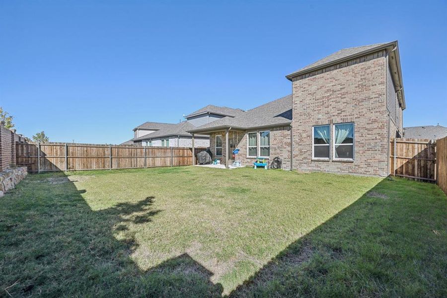 Back of property featuring a patio area and a lawn