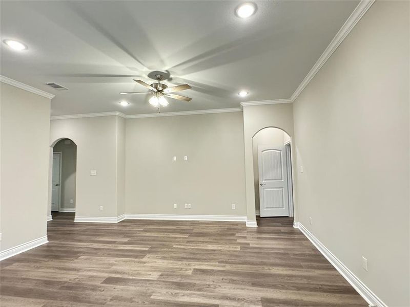 Empty room with hardwood / wood-style flooring, crown molding, and ceiling fan