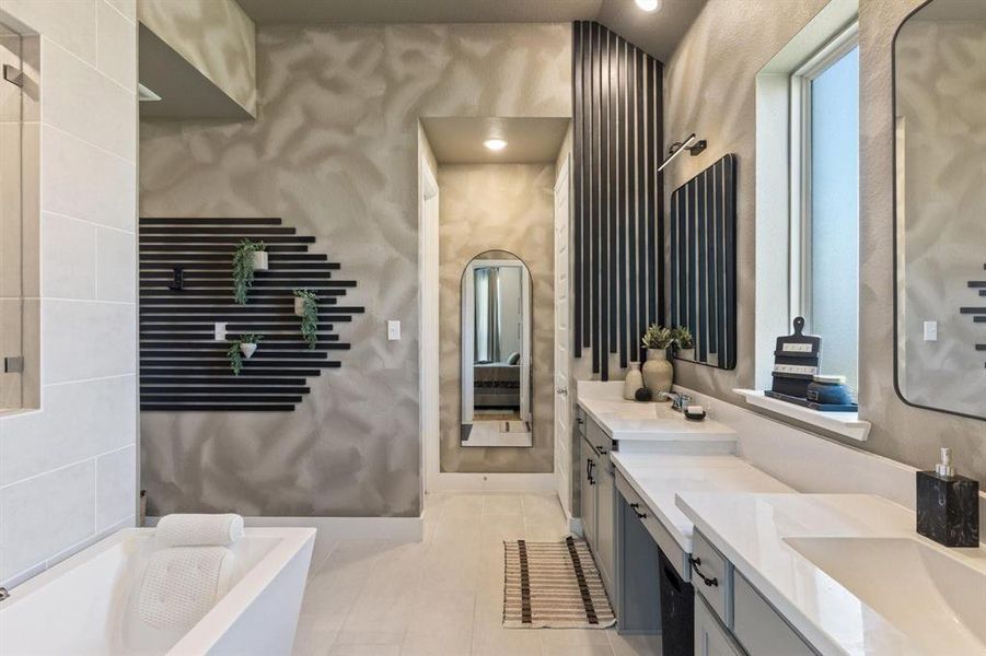 Bathroom featuring a tub to relax in, vanity, vaulted ceiling, and tile patterned floors