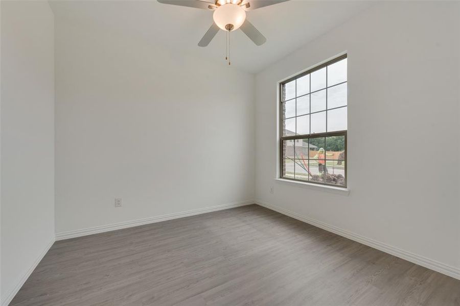 Empty room with ceiling fan and light hardwood / wood-style flooring