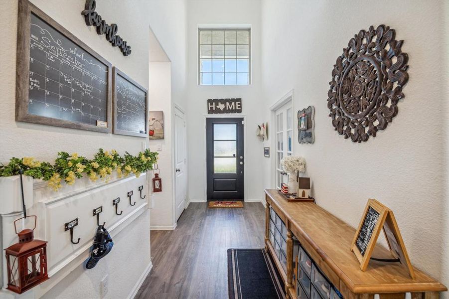 Another view of the spacious front entryway with the home office on the right and a hallway leading to the first-floor utility room, which offers a convenient bonus connection to the primary closet for easy access.