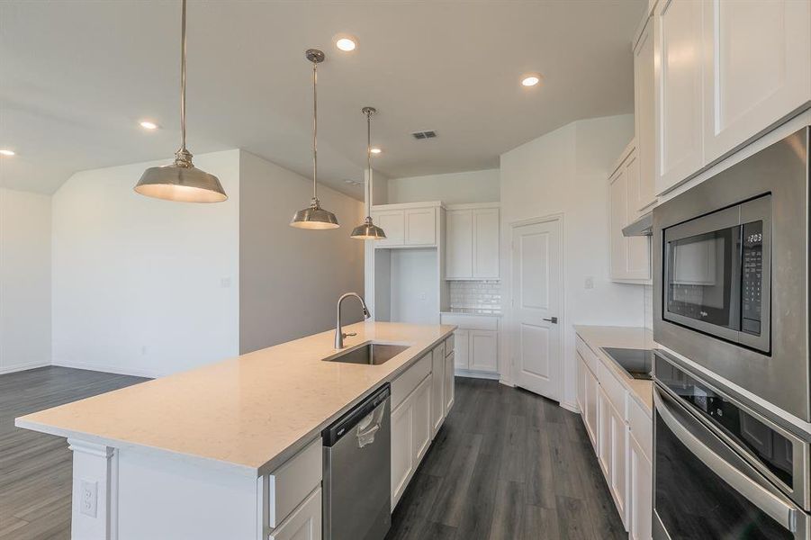 Kitchen featuring white cabinets, sink, a kitchen island with sink, appliances with stainless steel finishes, and dark hardwood / wood-style floors