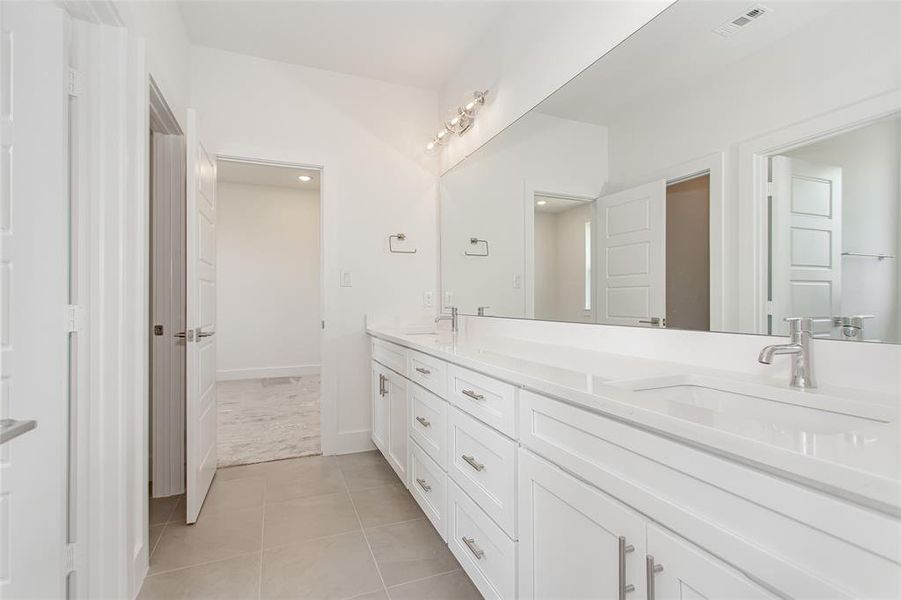 Bathroom with dual vanity and tile patterned flooring