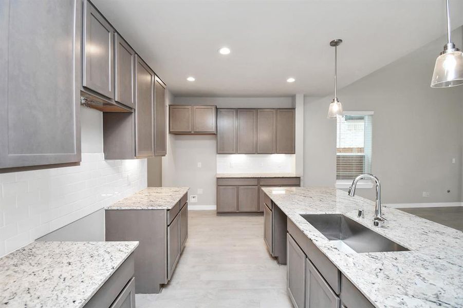 Discover another perspective of this stunning kitchen, generously appointed with an abundance of counter space. Sample photo of completed home with similar floor plan. Actual colors and selections may vary.