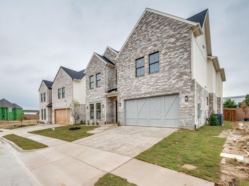 View of front of property with a garage and central AC