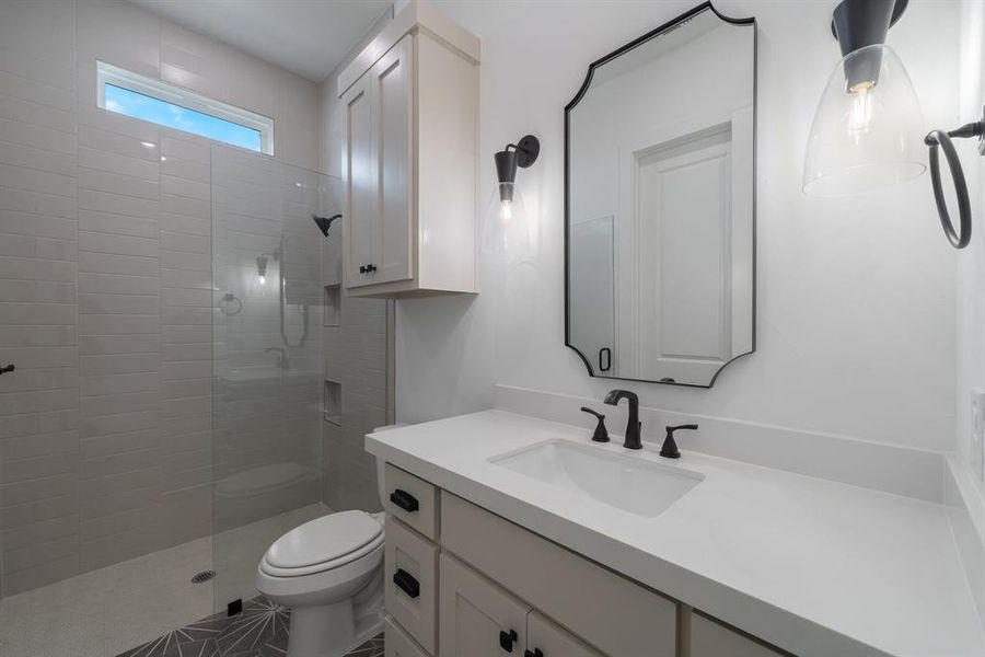 Bathroom featuring vanity, an enclosed shower, and toilet