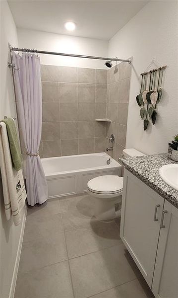 Full bathroom featuring tile floors, toilet, shower / bathtub combination with curtain, and vanity