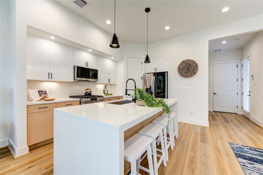 This luxurious kitchen comes with smart appliances, white quartz waterfall counters, modern European style soft-close cabinetry, walk-in pantry, and more! Fridge included!