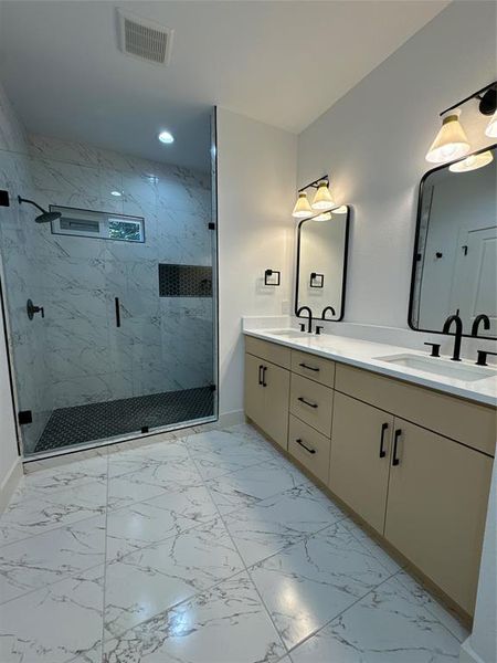 Bathroom featuring vanity and a shower with shower door