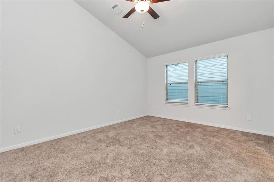 Relax and recharge in the expansive primary bedroom featuring plush carpet flooring and dual windows that flood the room with natural light. The room's neutral palette is a perfect canvas for any decor style, making it easy to create your personal oasis. **This image is from another Saratoga Home - Clover floorplan.**