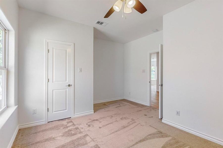 Spare room with ceiling fan and light colored carpet