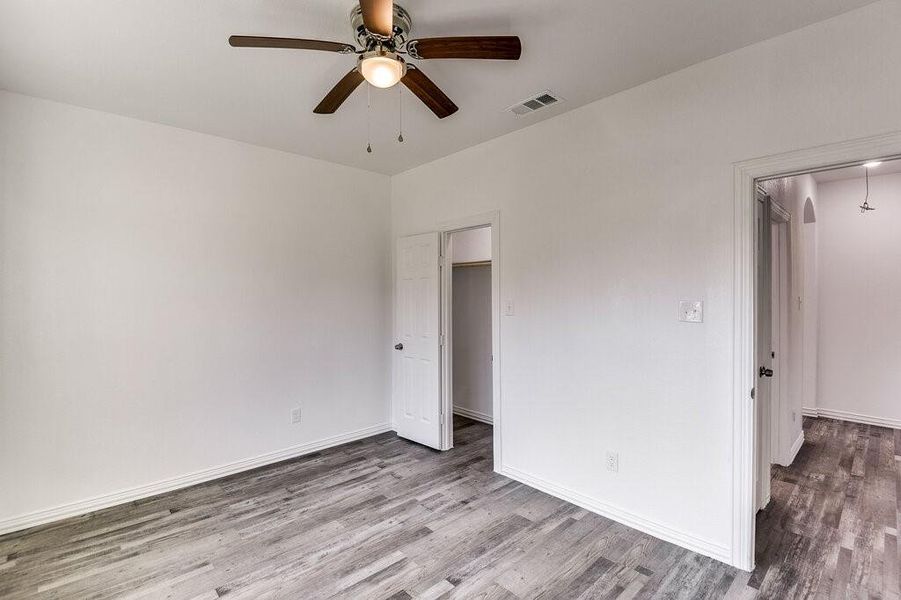 Unfurnished bedroom with wood-type flooring and ceiling fan