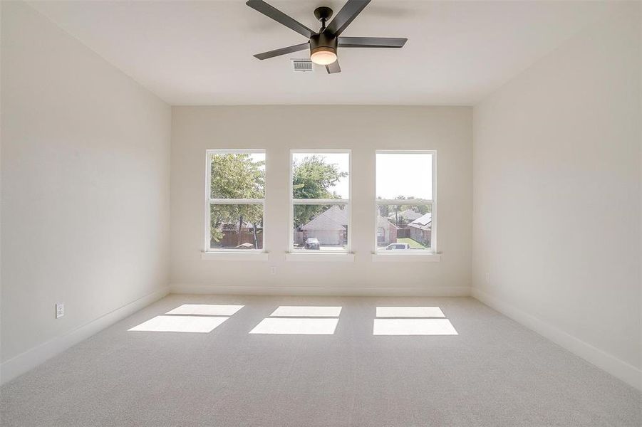 This spacious secondary bedroom is filled with natural lighting.