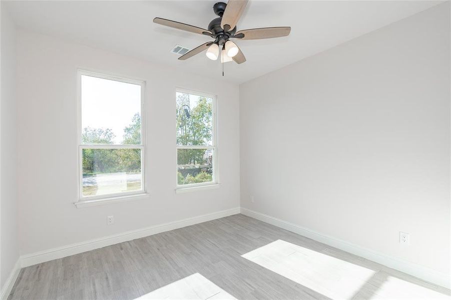 Spare room with light wood-type flooring and ceiling fan