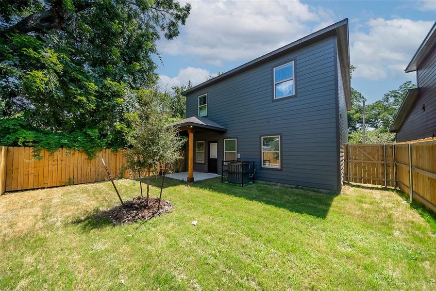 Back of house with a yard and a patio area