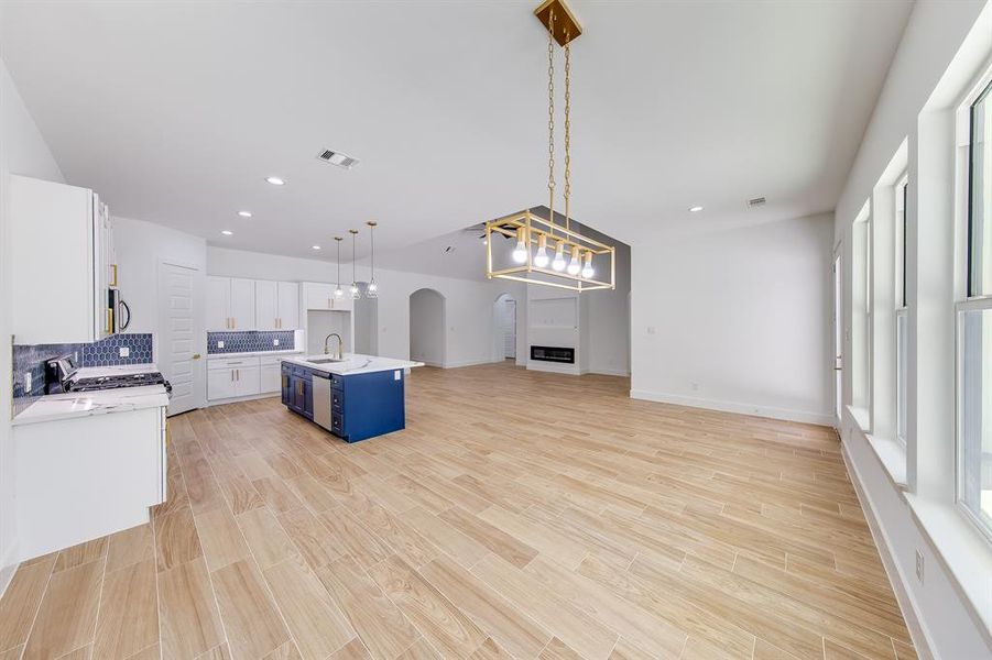 This dining area seamlessly connects to both the kitchen and living room, offering an open-concept flow perfect for entertaining. Bathed in natural light from large windows, the space overlooks a covered patio that invites you to enjoy the view of the expansive half-acre lot.