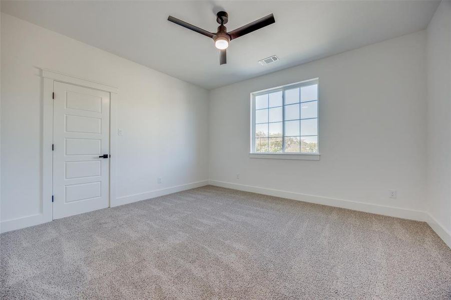 Empty room featuring carpet flooring and ceiling fan