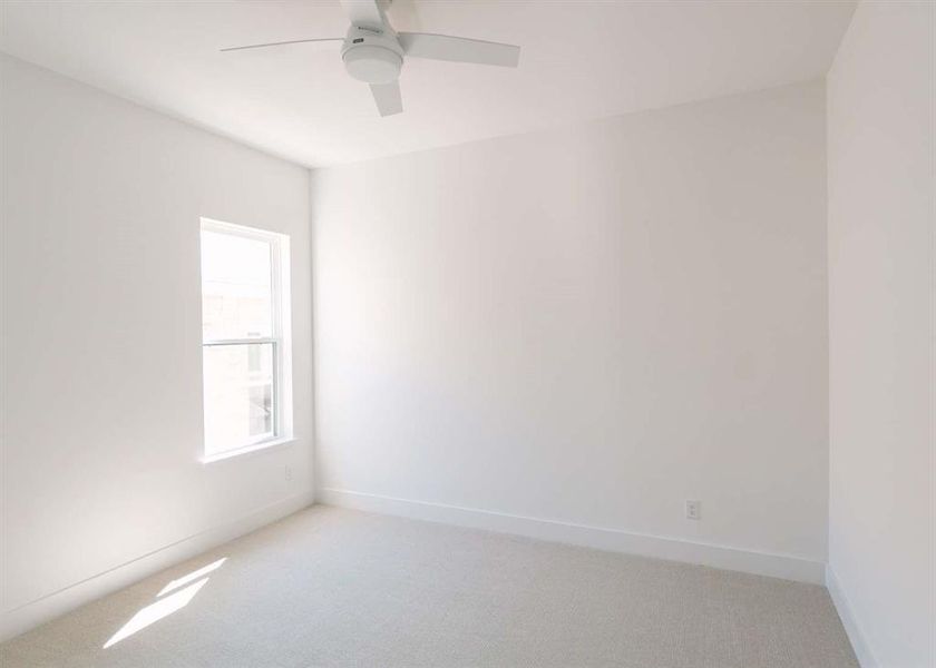 Spare room featuring ceiling fan and light colored carpet