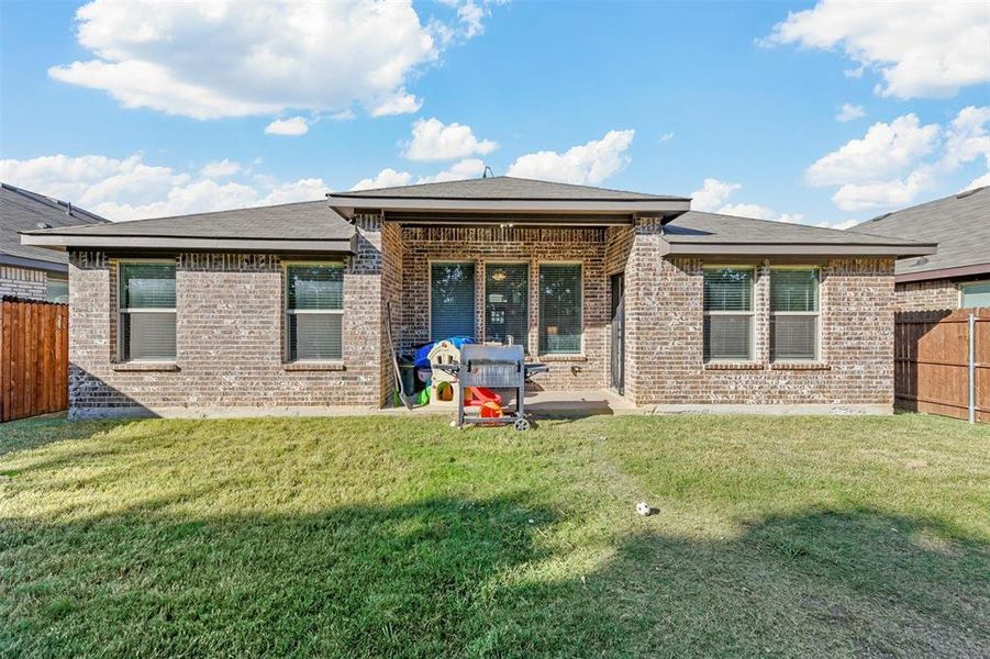 Back of house with a patio area and a lawn