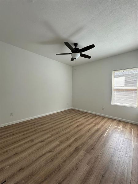 Spare room with ceiling fan, a textured ceiling, and hardwood / wood-style flooring