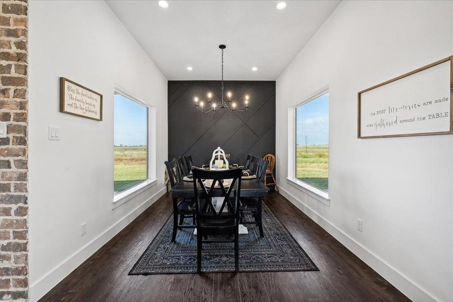 Dining space featuring a wealth of natural light, dark hardwood / wood-style flooring, and an inviting chandelier