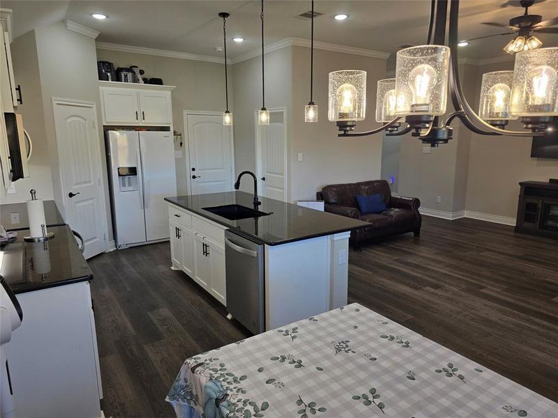 Kitchen with ceiling fan with notable chandelier, white fridge with ice dispenser, white cabinetry, and dishwasher