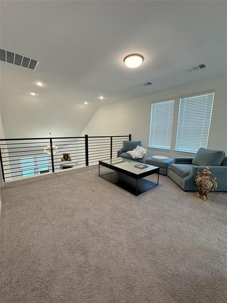 Living room featuring carpet and vaulted ceiling