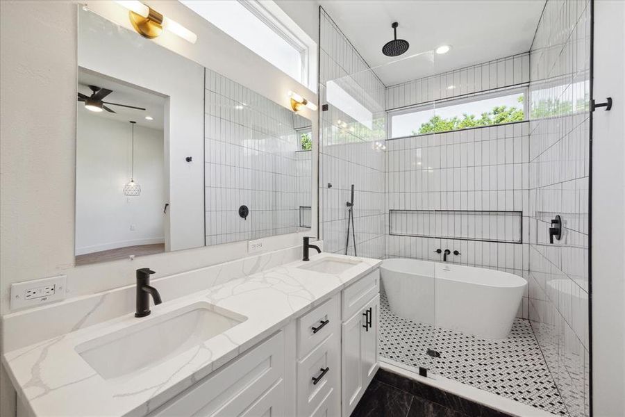 The primary bathroom features tile floors, dual sinks, white cabinets, walk-in shower with tile surround and soaking tub! Enjoy the spacious wet room with porcelain white tub and a resort style waterfall shower faucet.