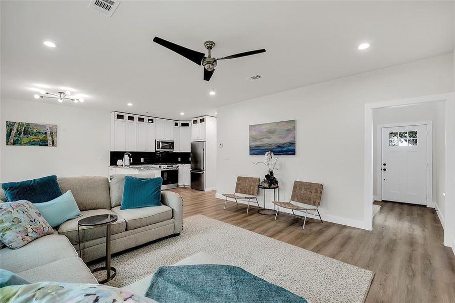 Living room featuring ceiling fan, light wood-type flooring