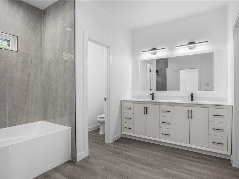 Bathroom featuring toilet, hardwood / wood-style flooring, and dual bowl vanity