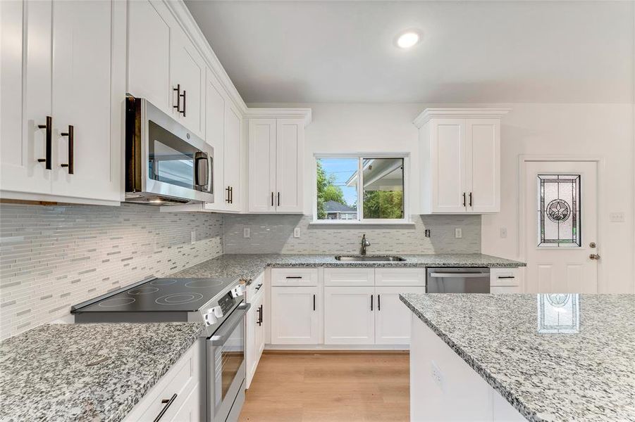 Immaculate white cabinetry with soft-closing hinges showcases the attention to detail and quality craftsmanship in this gourmet kitchen. (Virtual Staging May Be Present)