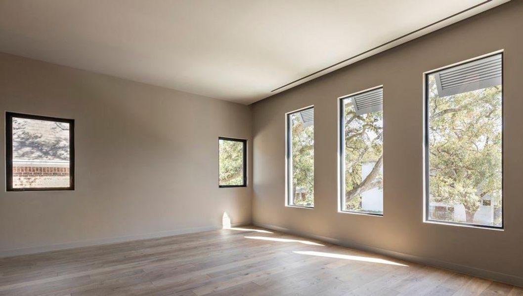 The master bedroom has leafy green views of neighboring trees, and is infused with transformational light, thanks to architectural designer, Scott Strasser.