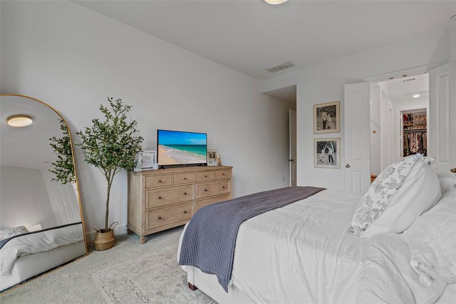 Bedroom featuring light carpet