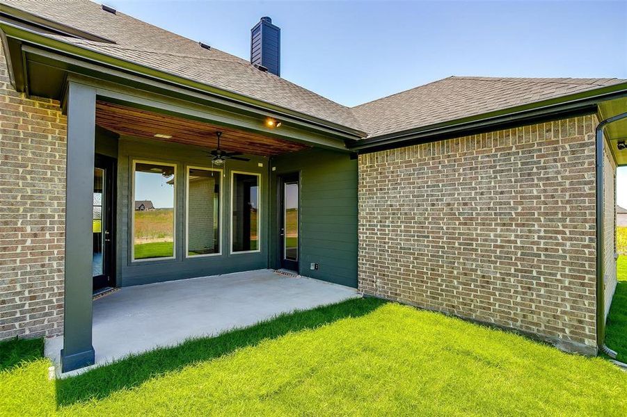 Back of property featuring a patio, ceiling fan, and a lawn