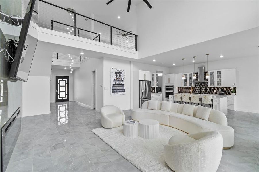 Living room with a towering ceiling and ceiling fan