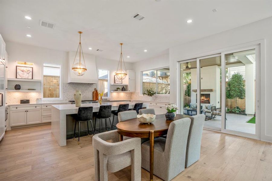 Welcome into this open-concept floor plan that is spacious enough for a breakfast table in front of your quartz waterfall kitchen island. Notice sconce lighting and under cabinet lighting along the entire back wall.