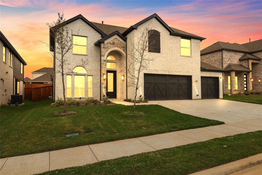 French provincial home featuring a yard, a garage, and central AC unit